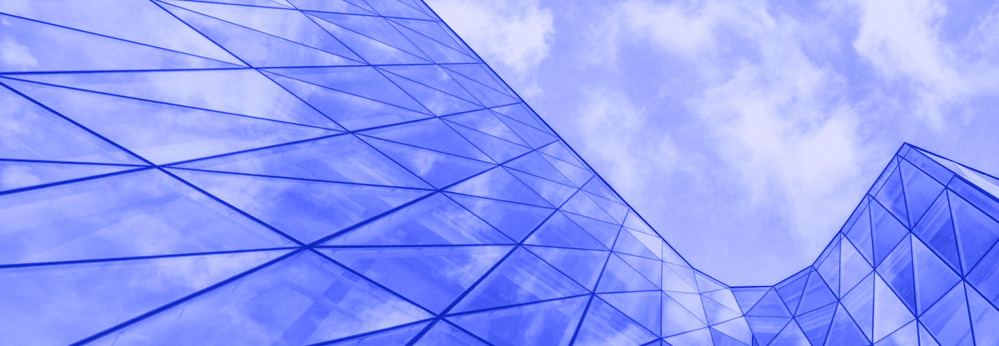 Abstract image of a modern glass building reflecting the sky, creating geometric patterns with a sleek, architectural design.